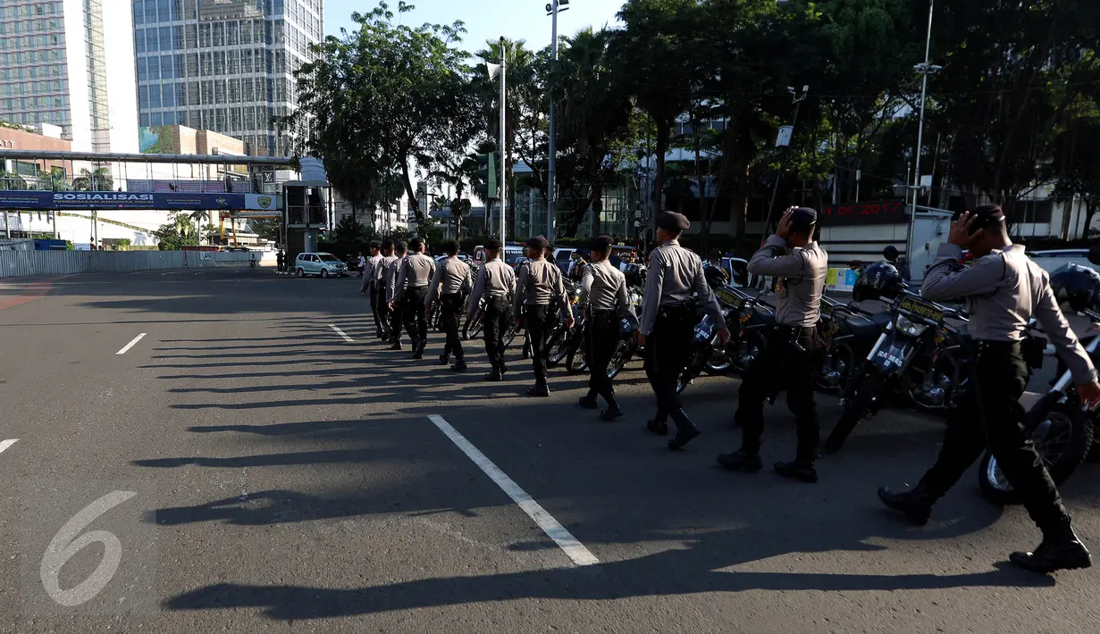 Sejumlah petugas kepolisian bersiap melakukan penjagaan di kawasan Bundaran HI, Jakarta, Senin (1/5). Seperti diketahui, puluhan ribu buruh akan berkumpul ke Ibu Kota untuk mengelar unjuk rasa peringatan Hari Buruh Internasional (Liputan6.com/Johan Tallo)
