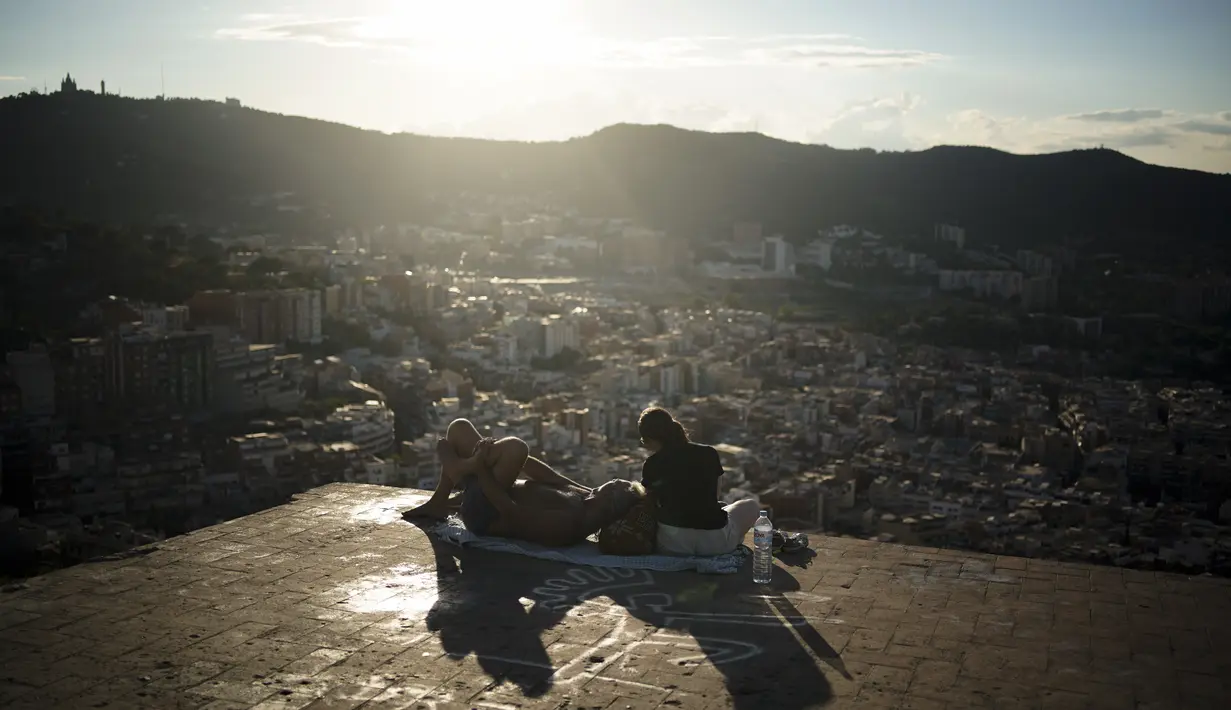 Sepasang suami istri duduk di sudut panorama kota Barcelona, Spanyol, Senin (21/10/2021). Berdiri pada 230 SM sebagai salah satu kota Kerajaan Romawi, di zaman pertengahan Barcelona menjadi ibu kota County Barcelona. (AP Photo/Joan Mateu)