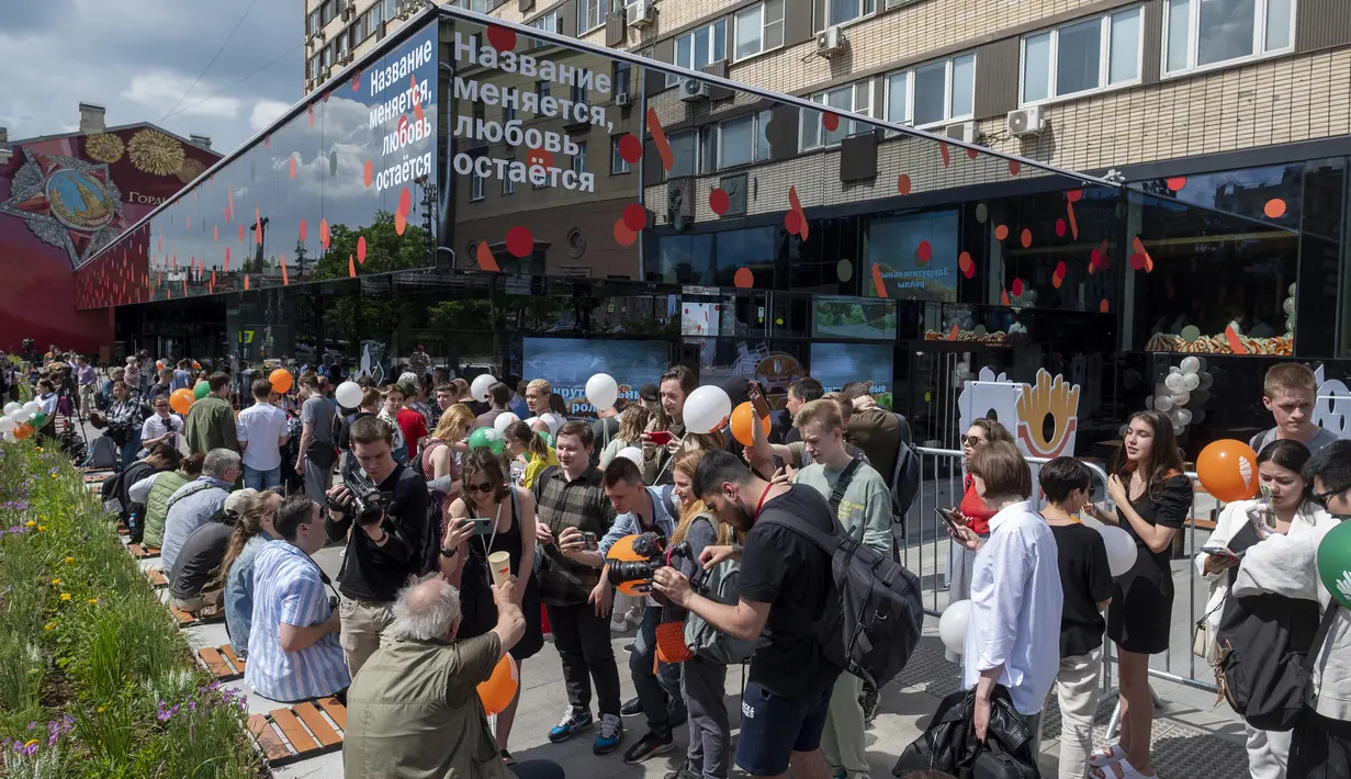 Warga berbaris untuk mengunjungi restoran cepat saji yang baru dibuka di bekas gerai McDonald's di Bolshaya Bronnaya Street, Moskow, Rusia, 12 Juni 2022. Papan itu bertuliskan 'Nama Berubah, Cinta Tetap'. (AP Photo/Dmitry Serebryakov)