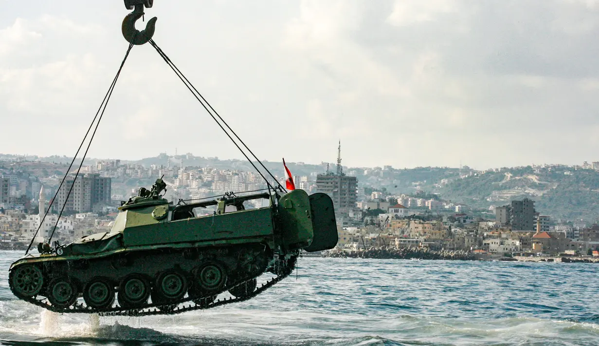 Aktivis lingkungan menurunkan tank lama ke dasar Laut Mediterania di lepas pantai kota pelabuhan Sidon, Lebanon, Sabtu (28/7). Para aktivis berharap rumput laut akan segera menutupi tank, yang merupakan hadiah dari militer tersebut. (AFP / Mahmoud ZAYYAT)