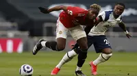 Gelandang Manchester United, Paul Pogba berebut bola dengan bek Tottenham, Serge Aurier pada pertandingan Liga Inggris di Stadion Tottenham Hotspur, London (12/4/2021).  Berkat kemenangan tersebut MU berada di posisi kedua klasemen dengan 63 poin. (Adrian Dennis/Pool via AP)