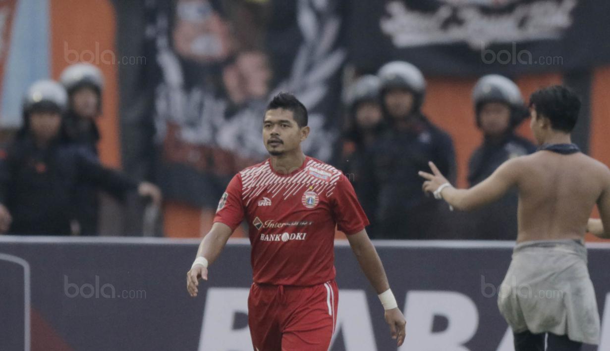 Striker Persija, Bambang Pamungkas, berjalan usai dipeluk The Jakmania saat melawan Mitra Kukar pada laga perempat final Piala Presiden di Stadion Manahan, Solo, Minggu, (4/2/2018). Persija menang 3-1 atas Mitra Kukar. (Bola.com/M Iqbal Ichsan)