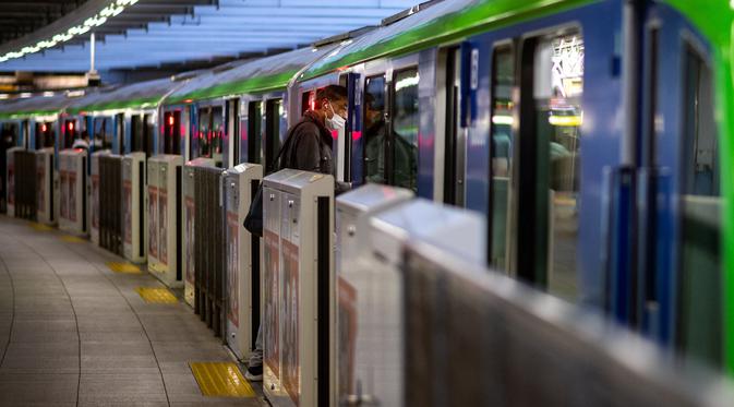 Seorang pria menaiki kereta Tokyo Monorail Haneda Airport Line di stasiun Terminal 3 bandara Haneda, Selasa (30/11/2021). Jepang melarang semua warga asing memasuki negaranya mulai Selasa (30/11) hingga sebulan ke depan untuk mengantisipasi penyebaran varian Covid-19 Omicron.  (Philip FONG/AFP)