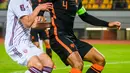 Pemain Latvia Kaspars Dubra (kiri) berebut bola dengan pemain Belanda Virgil van Dijk pada pertandingan sepak bola kualifikasi Grup G Piala Dunia 2022 di Stadion Daugava, Riga, Latvia, 8 Oktober 2021. Belanda menang 1-0. (Gint Ivuskans/AFP)