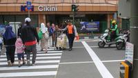 Pejalan kaki melintasi penyeberangan pejalan kaki yang dikontrol lampu lalu lintas atau dikenal sebagai persimpangan pelikan (pelican crossing) di sisi timur Stasiun Cikini, Jakarta, Senin (15/9/2025). (merdeka.com/Arie Basuki)