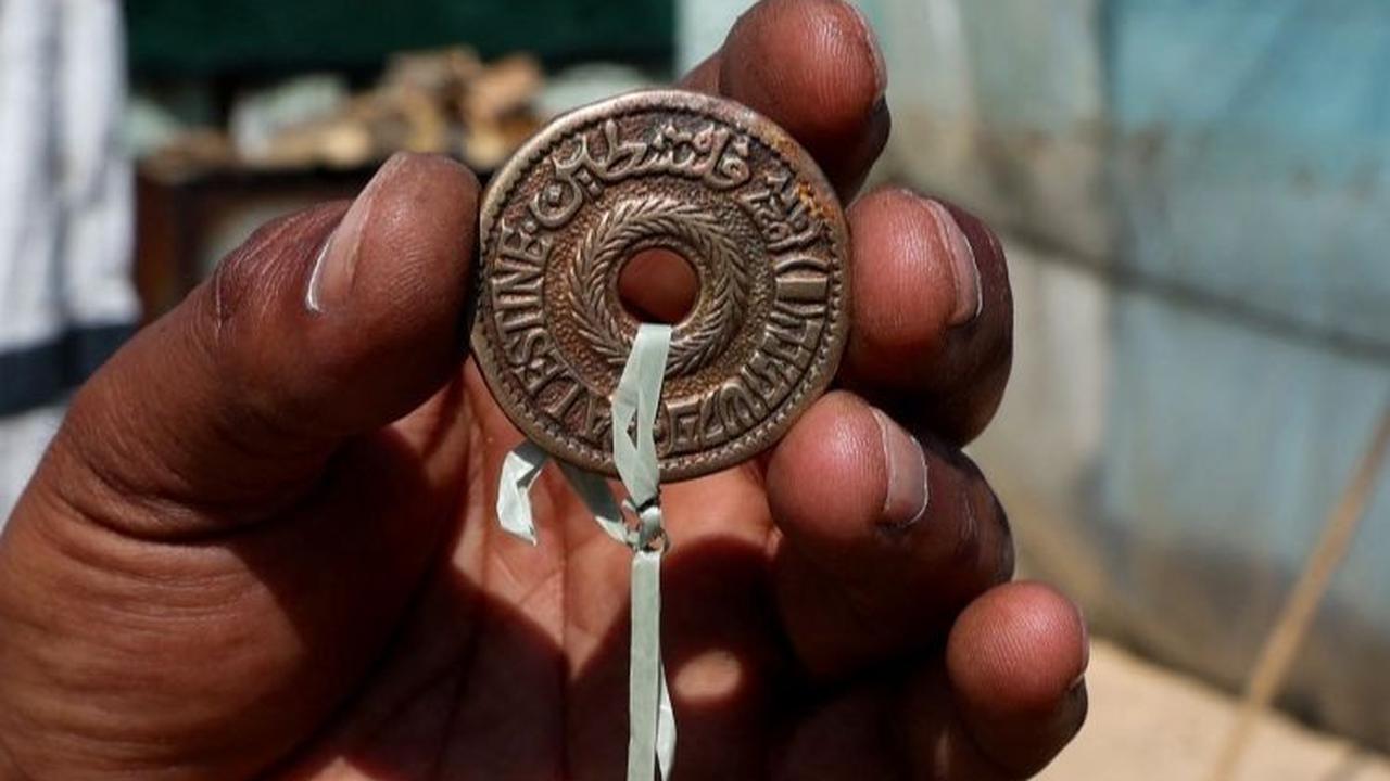 “Hanya kunci inilah yang tersisa dari rumah ini,” katanya sambil menunjukkan sebuah kunci yang diikatkan pada sebuah gantungan kunci yang terbuat dari koin dengan tulisan “Palestina” di atasnya, yang menurutnya berasal dari periode Mandat Inggris,
