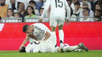 Carvajal mengerang sambil memegang lututnya saat tengkurap di lapangan. Rekan setimnya berusaha menenangkannya sambil meminta pertolongan medis. (AP Photo/Bernat Arnangue)