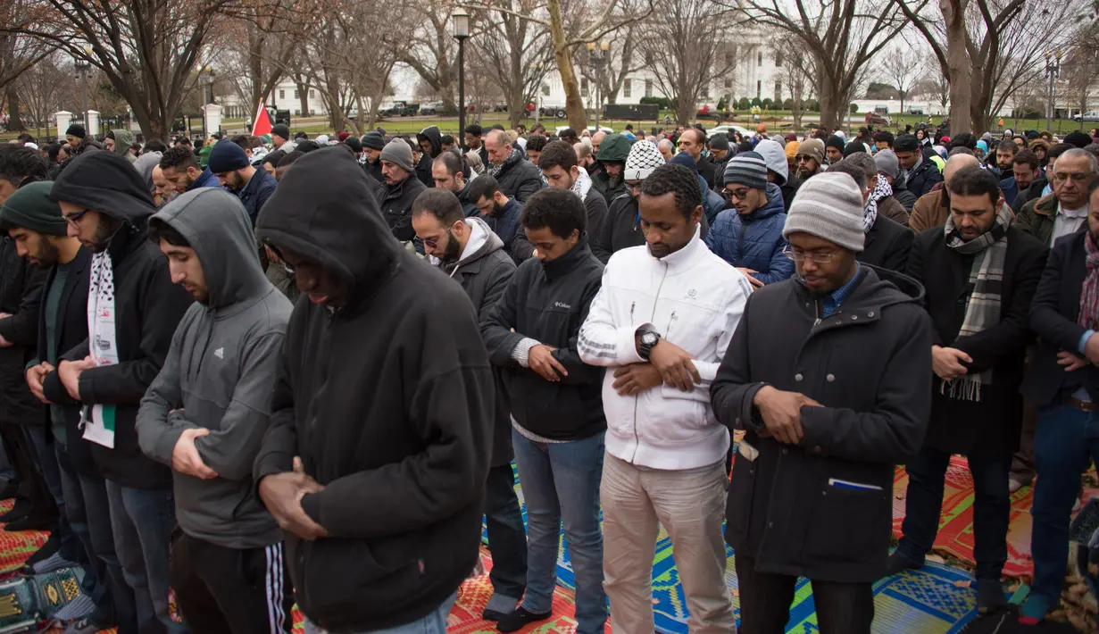 Warga Muslim melaksanakan Salat Jumat berjamaah di depan Gedung Putih, Washington DC, Amerika Serikat (AS), Jumat (8/12). Para warga muslim ini memprotes keputusan Presiden AS Donald Trump mengakui Yerusalem sebagai ibu kota Israel. (mari matsuri / AFP)