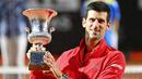 Petenis Serbia, Novak Djokovic, mengangkat trofi usai menjuarai Italia Terbuka di Roma, Senin (21/9/2020). Djokovic mengalahkan petenis Argentina, Diego Schwartzman, dengan skor 7-5 dan 6-3. (Alfredo Falcone/LaPresse via AP)
