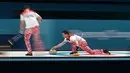 Atlet curling Norwegia, Thomas Ulsrud tampil bertanding melawan Amerika Serikat pada perhelatan Olimpiade Musim Dingin Pyeongchang 2018, Minggu (18/2). Atlet curling tersebut mengenakan celana merah bergambar bunga biru dan putih. (AP/Aaron Favila)