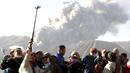 Wisatawan berfoto dengan latar belakang semburan abu vulkanik dari Gunung Bromo yang sedang erupsi di Ngadisari, Probolinggo, Jawa Timur, Rabu (6/1/2016). (REUTERS/Darren Whiteside)