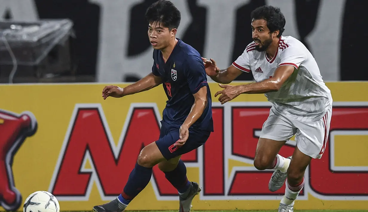 Pemain Thailand, Ekanit Panya (kiri) berebut bola dengan pemain Uni Emirat Arab, Mohamed Saleh Al Menhali pada laga kualifikasi Piala Dunia 2022 Qatar di Bangkok, Thailand (15/10/2019). Ekanit Panya menjadi pemain kedua Thailand yang berlaga di Meiji Yasuda J1 League musim 2023 bergabung dengan Supachok Sarachat yang bermain di Hokkaido Consadole Sapporo. (AFP/Chalinee Thirasupa)