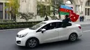 Rakyat Azerbaijan mengibarkan bendera nasional dan Turki di Baku, Azerbaijan, Selasa (10/11/2020). Armenia dan Azerbaijan mengumumkan perjanjian damai untuk menghentikan pertempuran atas wilayah Nagorno-Karabakh di Azerbaijan berdasarkan pakta yang ditandatangani dengan Rusia. (AP Photo)