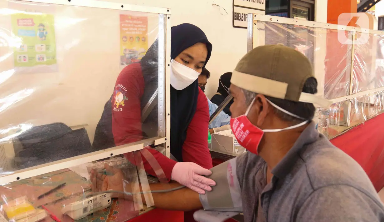Petugas kesehatan mengecek kesehatan pengemudi bus di Terminal Kampung Rambutan, Jakarta, Kamis (24/3/2022). Pemeriksaan kesehatan dan tes urine kepada pengemudi bus AKAP untuk mencegah terjadinya kecelakaan akibat penyalahgunaan narkoba dan obat-obatan. (Liputan6.com/Herman Zakharia)