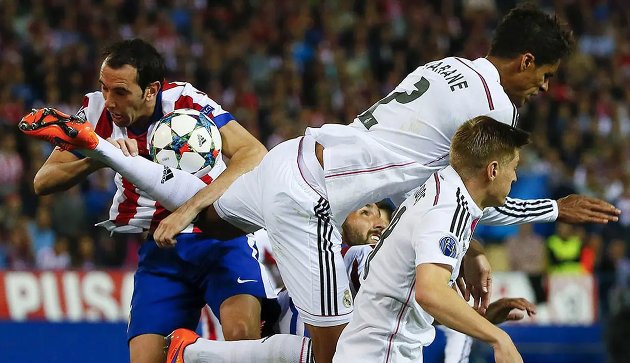 Kepala bek Atletico Madrid, Diego Godin, terkena kaki bek Real Madrid, Raphael Varane, pada laga perempat final Liga Champions di Stadion Vicente Calderon, Spanyol, Selasa (14/4/2015). (EPA/Juanjo Martin)