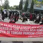 Ratusan pegiat seni menggelar aksi unjuk rasa di depan kantor Bupati Blora, Senin (29/6/2020). Aksi turun ke jalan menuntut kejelasan status pembatasan sosial terkait Covid-19 itu, sempat membuat macet jalan di sekitar lokasi. (Liputan6.com/ Ahmad Adirin)