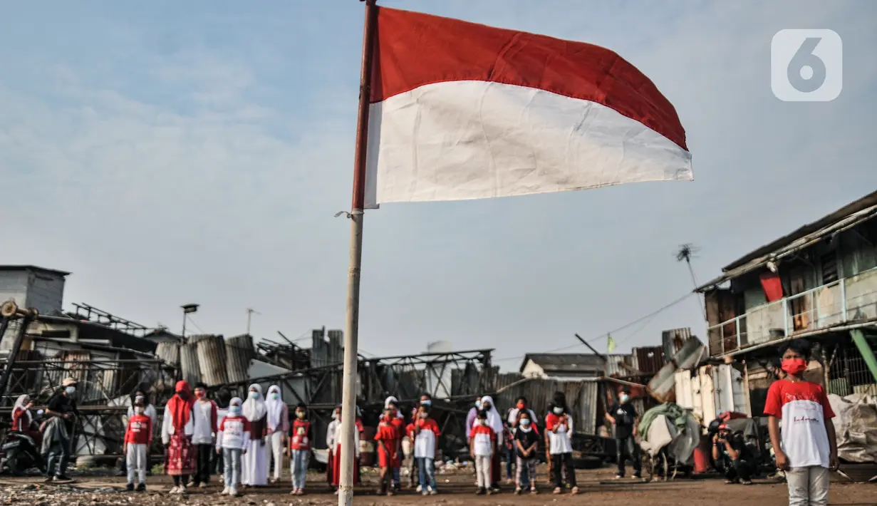 Anak-anak Kelas Jurnalis Cilik (KJC) saat menggelar upacara memperingati Hari Kemerdekaan ke-76 Republik Indonesia di Cilincing, Jakarta, Selasa (17/8/2021). Upacara peringatan HUT ke-76 RI yang digelar di kawasan pesisir tersebut berlangsung khidmat. (merdeka.com/Iqbal S. Nugroho)