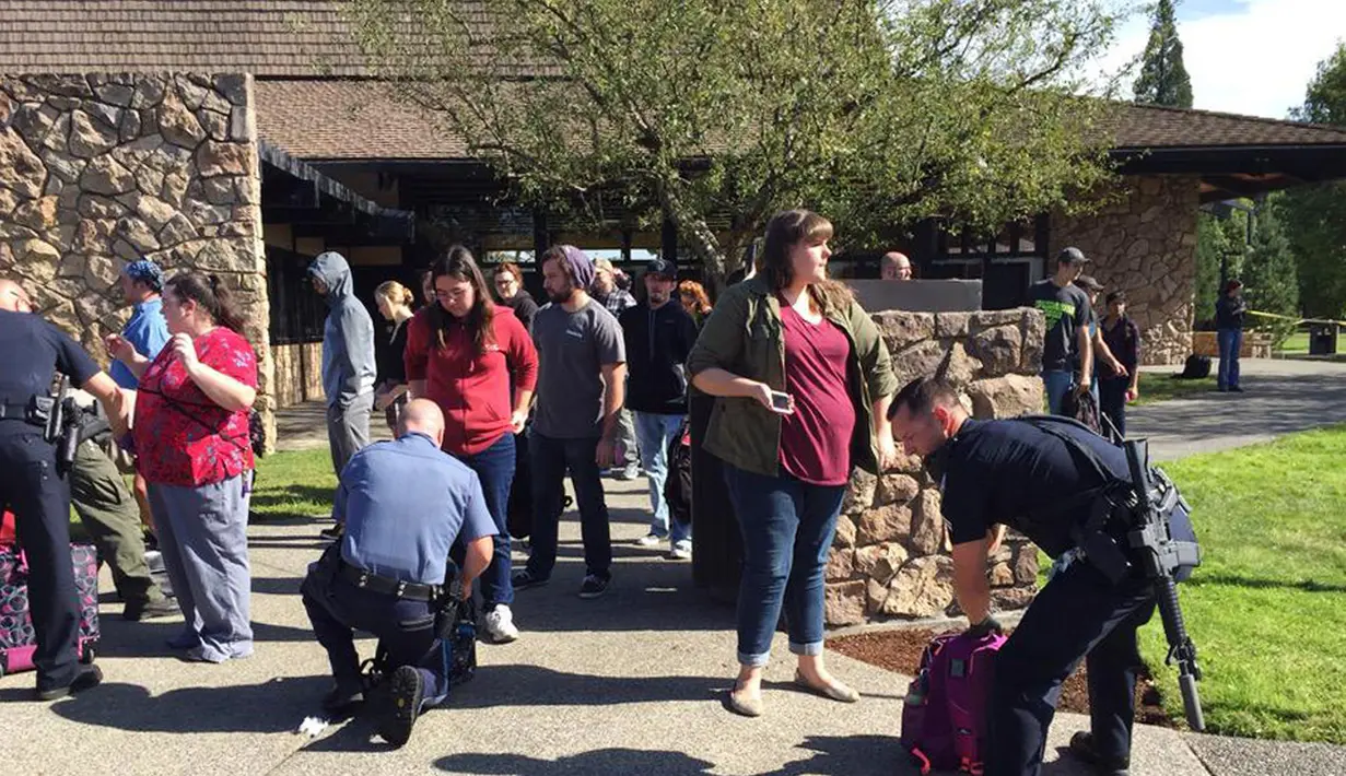 Polisi memeriksa tas mahasiswa dan staf setelah terjadi penembakan di Umpqua Community College di Roseburg, Oregon, AS, Kamis (1/10/2015). 13 orang tewas dan sekitar 20 lainnya terluka akibat kejadian tersebut. (REUTERS/Michael Sullivan/The News-Review)