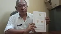 Kepala Kesbangpol Garut, Wahyudijaya menunjukan perubahan posisi Kepala Burung Garuda pada lambang negara Garuda Pancasila. (Liputan6.com/Jayadi Supriadin)