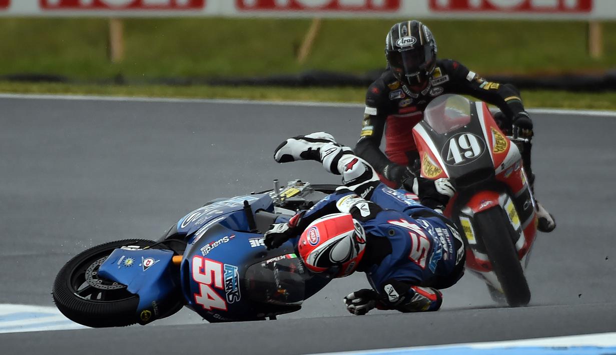 Pebalap Italtrans Racing, Mattia Pasini terjatuh dekat pebalap AGR team, Axel Pons pada sesi pertama pratice Moto 2 Australian Grand Prix di Phillip Island (22/10/2016). (AFP/Saeed Khan)