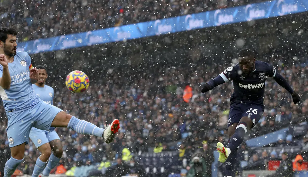 Gelandang Manchester City, Ilkay Gundogan berusah memblok bola tendangan pemain West Ham United, Arthur Masuaku pada pertandingan lanjutan Liga Inggris di stadion Etihad, Inggris, Minggu (28/11/2021). City menang tipis atas West Ham 2-1. (AP Photo/Scott Heppell)