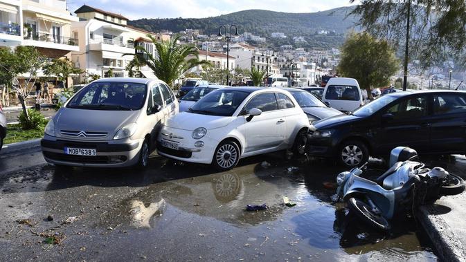 Mobil-mobil ditumpuk setelah gempa bumi di pelabuhan Vathi di timur pulau Aegean Samos, Yunani (30/10/2020). Gempa bumi kuat melanda Laut Aegea antara pantai Turki dan pulau Samos di Yunani. (AP Photo / Michael Svarnias)