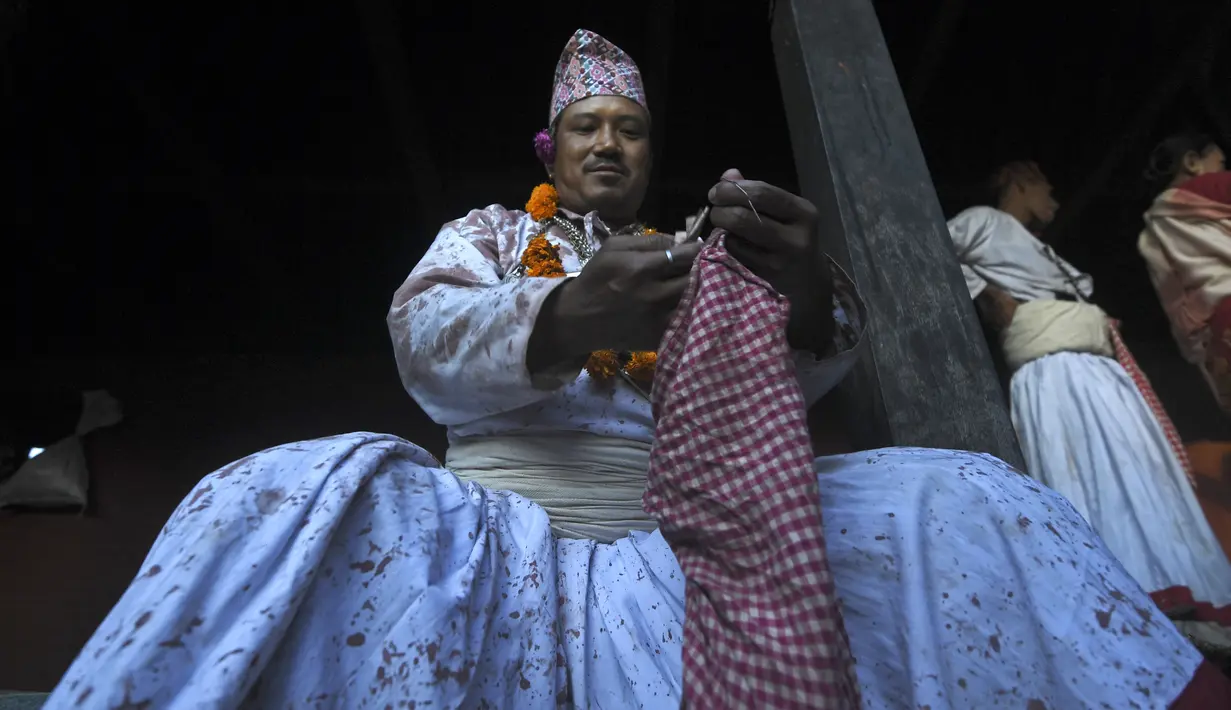 Seorang pendeta Hindu bersiap-siap untuk ambil bagian dalam perayaan pada hari kesepuluh festival Dashain di sebuah kuil di Bhaktapur di pinggiran Kathmandu (15/10/2021). (AFP/Prakash Mathema)