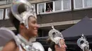 Seorang wanita melambai dan merekam dengan ponselnya dari jendela saat para penampil mengambil bagian dalam Karnaval Notting Hill tahunan di London barat, Senin (29/8/2022). Karnaval yang kembali ke jalanan untuk pertama kalinya dalam dua tahun, setelah digagalkan oleh pandemi, adalah salah satu perayaan festival terbesar dari jenisnya di Eropa. (AP Photo/Alberto Pezzali)