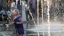 Seorang anak kecil melihat air mancur saat bermain dan menikmati musim panas di taman Gorky, Moskow, Rusia, Minggu (9/8/2015). (REUTERS/Sergei Karpukhin)
