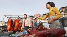 Pedagang menyiapkan babi panggang untuk perayaan Tahun Baru Imlek di Phnom Penh, Kamboja, Jumat (24/1/2020). Olahan daging babi menjadi salah satu makanan khas Imlek dan disantap oleh keluarga besar. (AP photo/Heng Sinith)