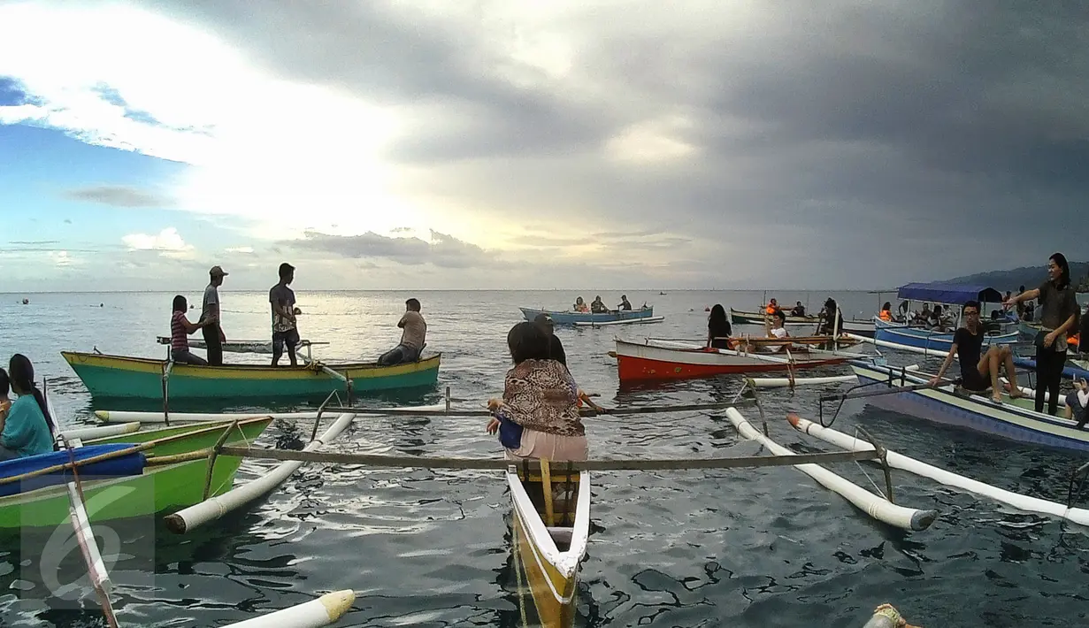 Wisatawan melihat Hiu Paus (Shark Whale) di atas perahu, Desa Botu Barani, Kabupaten Bone Bolango, Gorontalo, Senin (4/7). Kehadiran Hiu Paus menjadi sorotan wisatawan lokal dan mancanegara. (Liputan6.com/herman Zakharia)