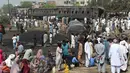 Warga berkumpul di dekat lokasi kecelakaan antara kereta penumpang dengan kereta tangki minyak di Distrik Sheikhupura, Punjab, Selasa (28/3). Sedikitnya dua orang termasuk masinis kereta tewas dalam kejadian tersebut. (AFP Photo / Ludovic Marin)