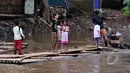 Masih banyak warga bantaran kali Ciliwung Jakarta yang memanfaatkan air kali untuk kehidupan sehari - hari. Tampak aktivitas warga saat menyebrangi kali Ciliwung, Jakarta, Jumat (20/2/2015). (Liputan6.com/JohanTallo)