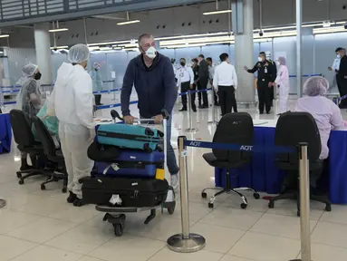 Seorang turis tiba di Bandara Internasional Suvarnabhumi di Bangkok, Thailand, Senin (1/11/2021). Thailand mulai Senin ini telah dibuka kembali untuk wisatawan mancanegara yang divaksinasi penuh tanpa perlu menjalani proses karantina Covid-19. (AP Photo/Sakchai Lalit)