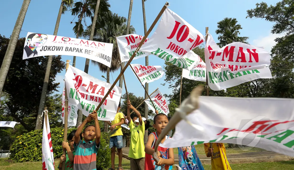 Sejumlah anak mengibarkan bendera bertuliskan dukungan terhadap Jokowi, di sekitar Tugu Proklamasi, Jakarta, Kamis (21/5/2015). Spanduk tersebut dipasang dalam rangka memperingati 17 tahun reformasi. (Liputan6.com/Faizal Fanani) 