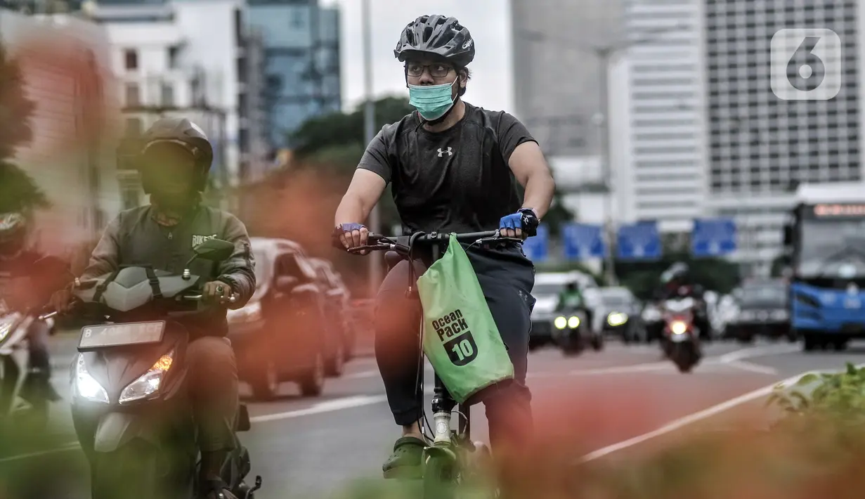 Pesepeda melintasi Jalan Jenderal Sudirman, Jakarta, Senin (18/1/2021). Dinas Perhubungan Provinsi DKI Jakarta mencatat volume lalu lintas pesepeda mengalami peningkatan 4,1 persen selama sepekan pengetatan Pembatasan Sosial Berskala Besar (PSBB). (merdeka.com/Iqbal S. Nugroho)