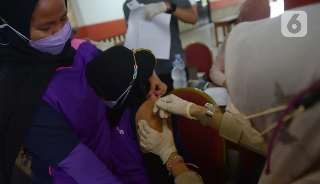 Petugas medis menyuntikkan vaksin kepada warga di Gor Ciracas, Jakarta, Sabtu (19/3/2022). Vaksin booster diberikan kepada warga lanjut usia dan masyarakat berisiko tinggi tertular Covid-19. (merdeka.com/Imam Buhori)