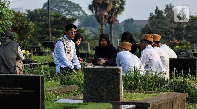 Warga berziarah di makam keluarganya di Tempat Pemakaman Umum (TPU) Tanah Kusir, Jakarta, Selasa (29/3/2022). TPU setempat semakin banyak dikunjungi warga yang melakukan tradisi ziarah kubur menjelang Ramadhan. (Liputan6.com/Johan Tallo)