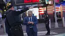 Petugas polisi mencatat saat melakukan investigasi di lokasi penembakan di Times Square di New York, AS (8/5/2021). Menurut pihak berwenang kasus penembakan tersebut dipicu dari pertengkaran antara sejumlah pria, di mana salah satunya melakukan penembakan. (AFP/Kena Betancur)