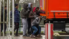 Sejumlah imigran terlihat tengah membuka pintu truk di A25 autoroute, Steenvoorde, Prancis (27/2). Para imigran ini nekat sembunyi saat menghindari kejaran petugas imigrasi. (AFP Photo / Philippe Huguen)