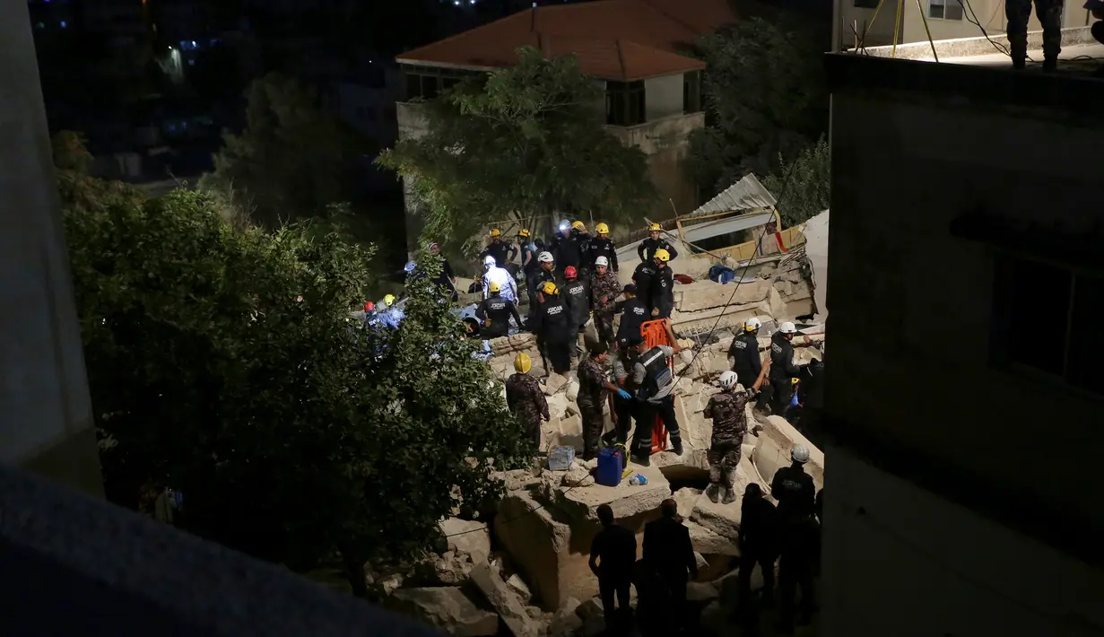 Tim penyelamat Pertahanan Sipil Yordania melakukan operasi pencarian terhadap penghuni sebuah bangunan perumahan berlantai empat yang runtuh di Amman, Yordania, Selasa (13/9/2022). Perdana Menteri Yordania Bisher Al Khasawneh sudah tiba di lokasi kejadian dan memerintahkan penyelidikan guna memastikan penyebabnya. (AP Photo/Raad Adayleh)