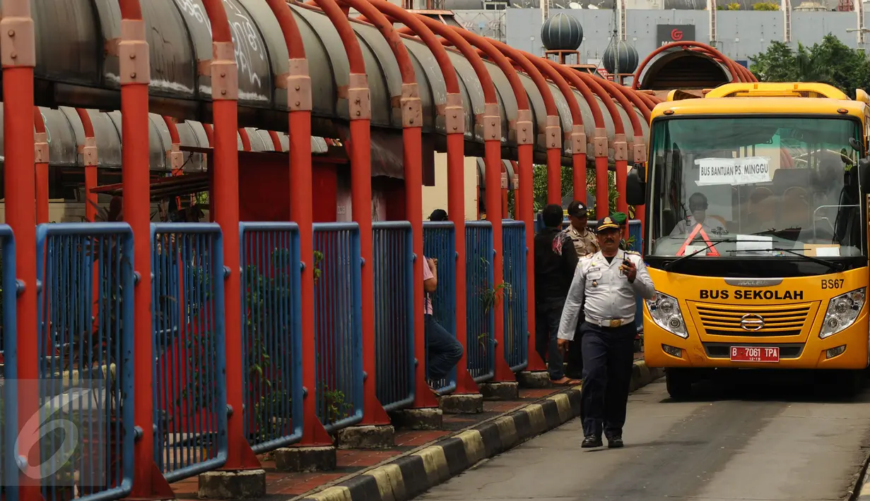 Petugas mengawal bus sekolah untuk mengangkut penumpang di Terminal Blok M Jakarta, Senin (21/12/2015). Bus sekolah dikerahkan untuk mengantisipasi penumpukan penumpang seiring mogoknya sejumlah sopir metromini. (Liputan6.com/Helmi Fithriansyah)