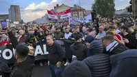 Suporter Manchester United menggelar pawai protes menjelang pertandingan Liga Inggris melawan Liverpool di Old Trafford, pada Senin, 22 Agustus 2022. Ribuan penggemar yang marah atas arahan klub di bawah pemiliknya di Amerika mengambil bagian dalam protes, meneriakkan menentang keluarga Glazer. (Andy Hampson/PA via AP)