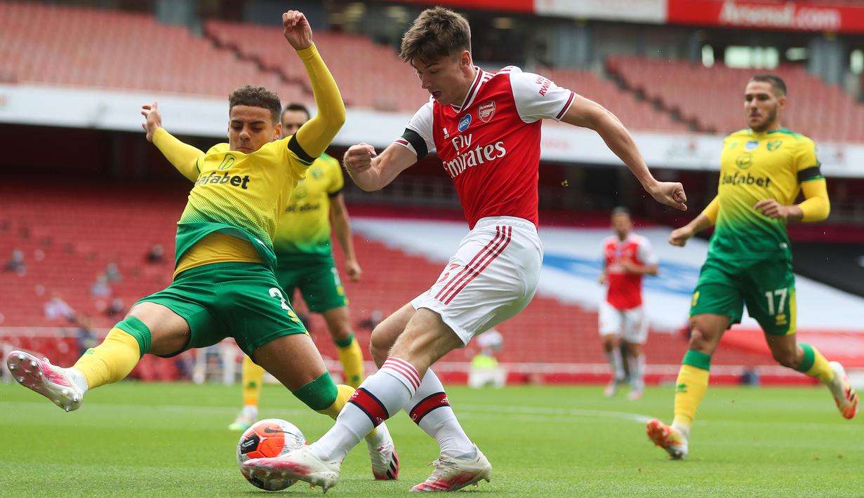 Bek Arsenal, Kieran Tierney, berebut bola dengan bek Norwich City, Max Aarons, pada laga lanjutan Premier League pekan ke-32 di Emirates Stadium, Kamis (2/7/2020) dini hari WIB. Arsenal menang 4-0 atas Norwich City. (AFP/Mike Egerton/pool)