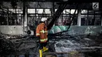 Petugas pemadam kebakaran mengamati sisa Stasiun Klender, Jakarta Timur yang terbakar, Jumat (19/5). Kebakaran yang terjadi sekitar 07.30 WIB di Stasiun Klender ini melalap kantor kepala stasiun hingga loket tiket. (Liputan6.com/Faizal Fanani)