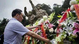 Seorang pria menempatkan bunga untuk orang-orang yang gugur di Aviation Martir Memorial dalam peringatan 69 tahun kemenangan rakyat Tiongkok melawan Jepang di Perang Dunia II, Nanjing, (3/9/2014). (AFP PHOTO/STR)