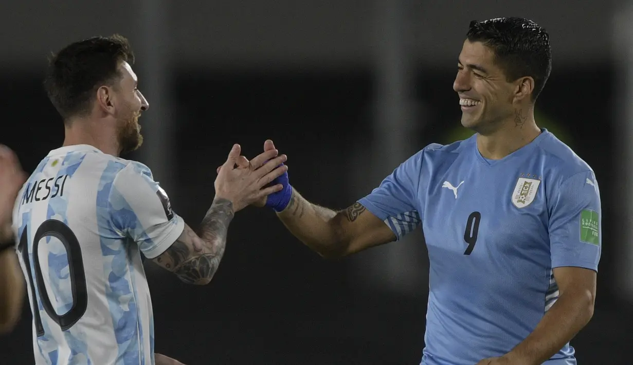 Penyerang Argentina Lionel Messi menyapa penyerang Uruguay Luis Suarez sebelum laga Kualifikasi Piala Dunia 2022 Zona Amerika Selatan di Monumental stadium, Senin (11/10/2021) pagi WIB. Duel ini menjadi momen reuni dua mantan pemain Barcelona, Messi dan Suarez. (Juan Mabromata/AFP)