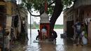 Sejumlah warga berdoa di sebuah kuil kecil saat air membanjiri perumahan dekat tepi Sungai Yamuna yang meluap di New Delhi, India, Selasa (20/8/2019). (AFP Photo/Sajjad Hussain)