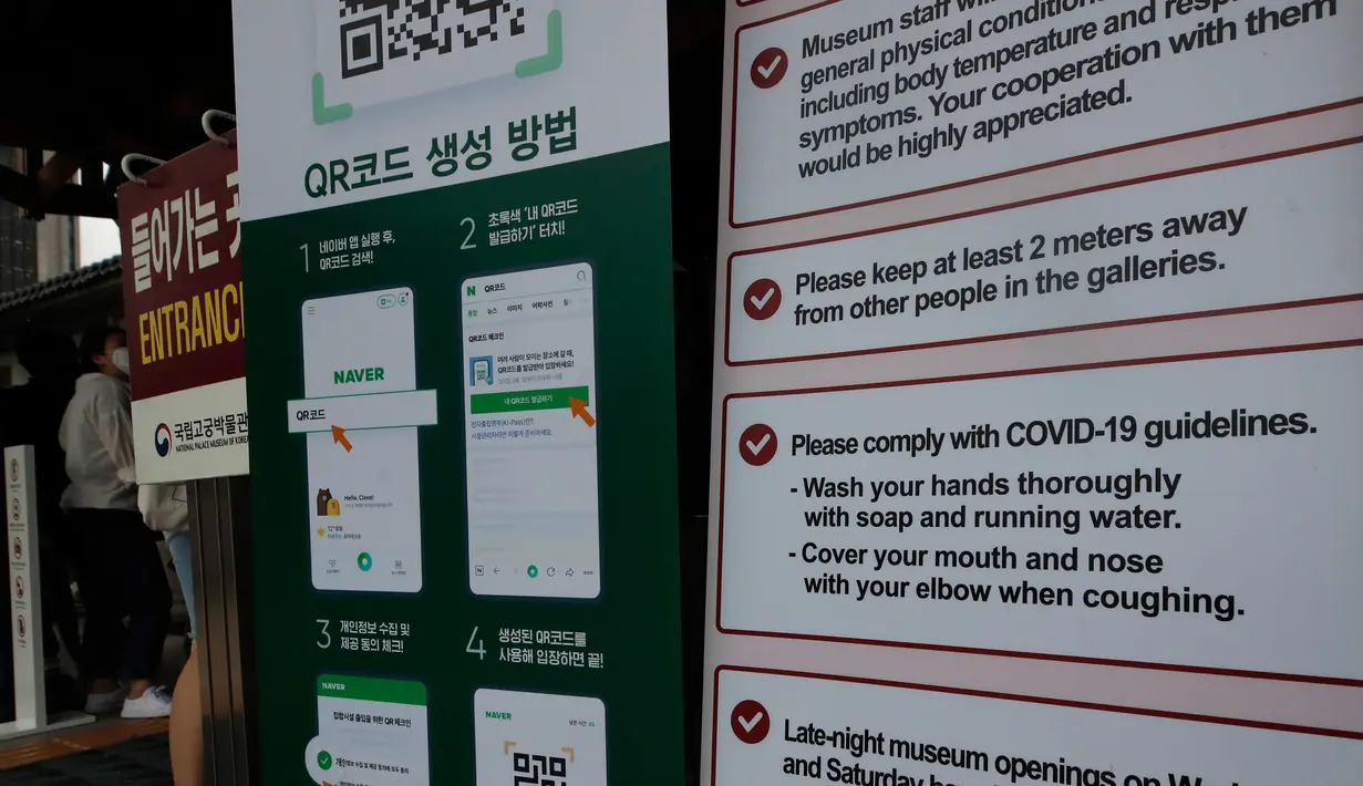 Pengunjung yang mengenakan masker berdiri di dekat instruksi pencegahan virus corona di Museum Nasional Korea di Seoul, Korea Selatan, Rabu (22/7/2020). Museum ini dibuka kembali pada Rabu (22/7) setelah ditutup selama dua bulan akibat pandemi Covid-19. (AP Photo/Ahn Young-joon)