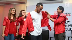 Giring Nidji dipakaikan jaket merah usai mendaftarkan diri menjadi anggota Partai Solidaritas Indonesia (PSI) di Jakarta, Rabu (6/9). Giring juga mendaftar sebagai calon legislatif dari PSI dalam Pemilu Legislatif 2019. (Liputan6.com/Herman Zakharia)